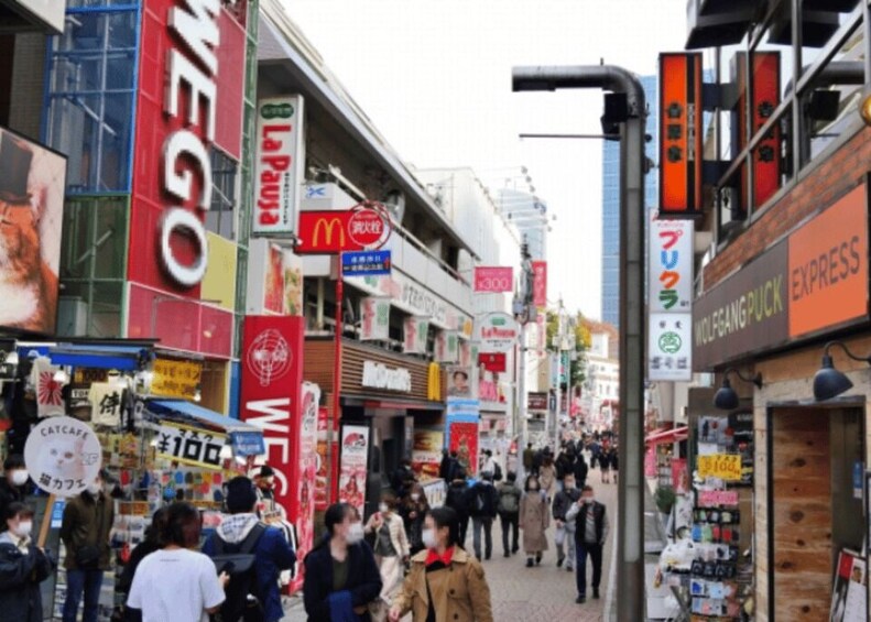 A busy street with various shops and signs, including a McDonald's and a cafe. 4