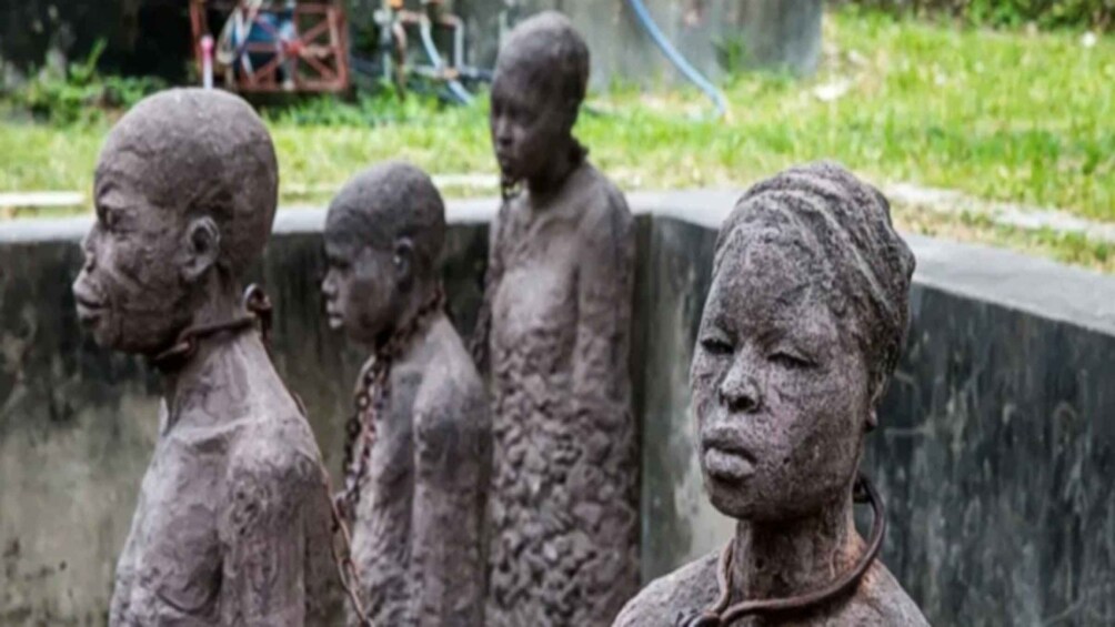 A row of statues with rough textures and simple features. 4