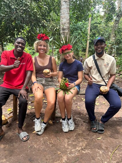 Four people sitting on a bench in a forested area. 2