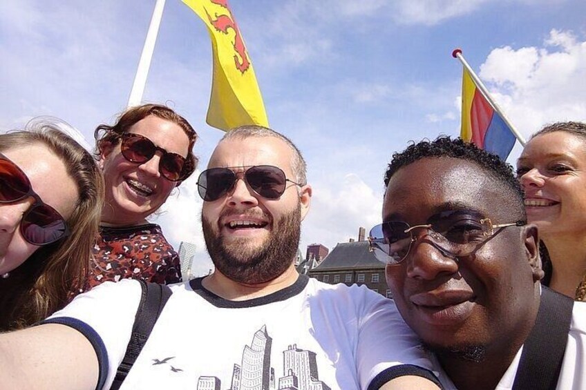 A group of people outdoors with flags in the background. 4