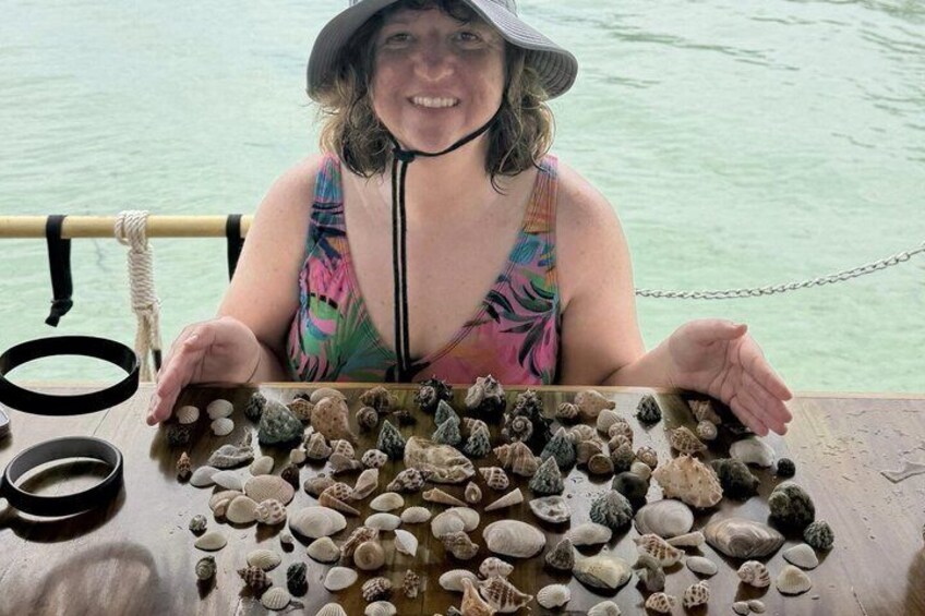 A person holding a collection of seashells on a boat. 5