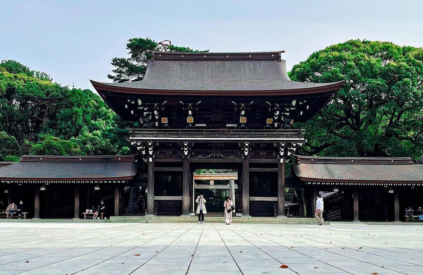 A traditional Japanese gate with a curved roof, surrounded by a spacious courtyard and lush greenery. 2