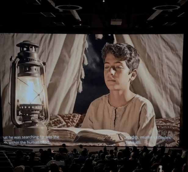 A person reading a book in a dimly lit room with a lantern on a table. 5