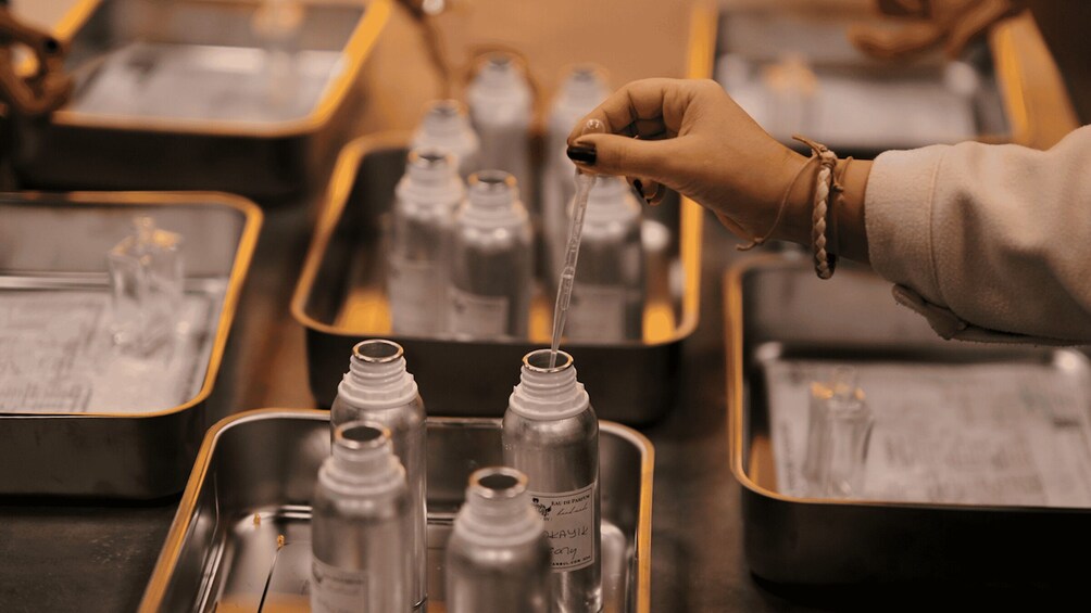 A person filling perfume bottles with water. 4