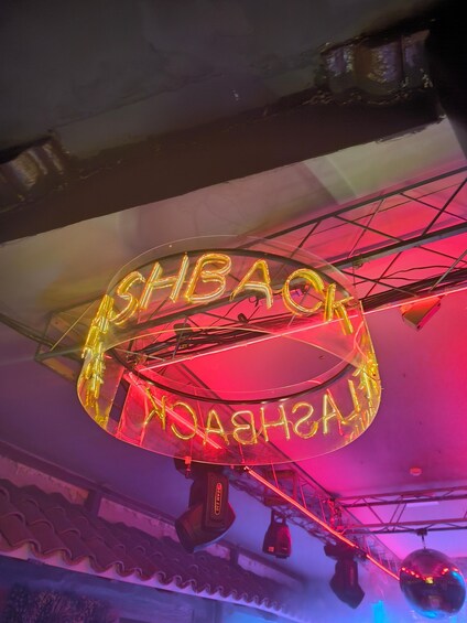 A neon sign with the text "SHBACK" in a circular design. 5