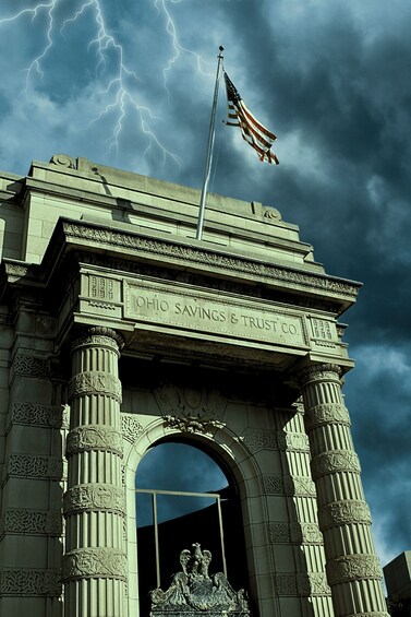 A stone archway with the inscription 'OHIO SAVINGS & TRUST CO.' and a flagpole with an American flag. 2