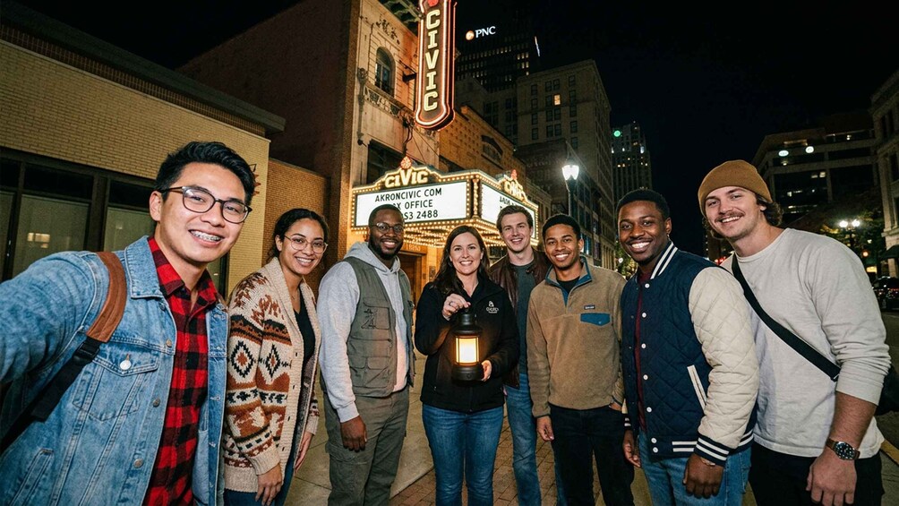 A group of people standing in front of a theater with a marquee that reads 'CIVIC.' 4