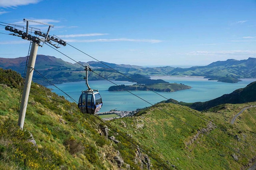 A cable car moving over a mountainous landscape with a lake in the background. 5