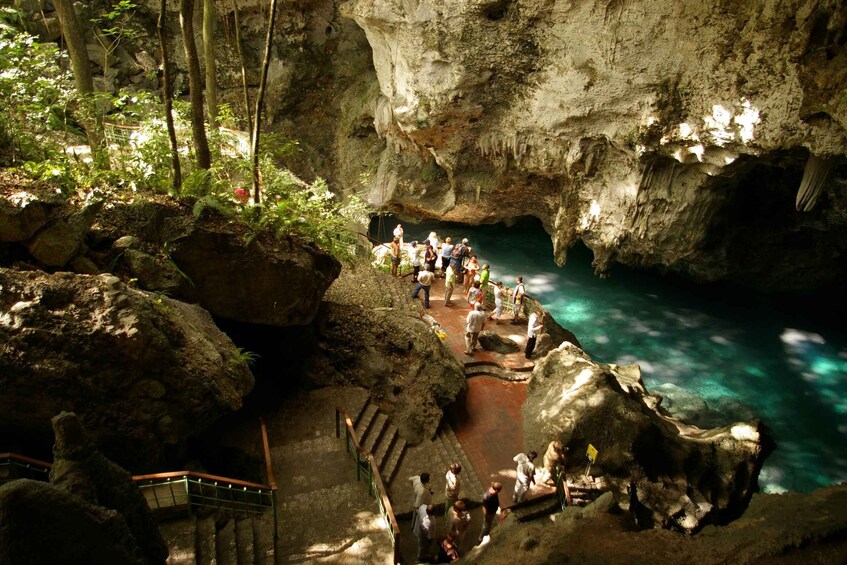 A cave with a water pool, rocky formations, and a staircase. 2