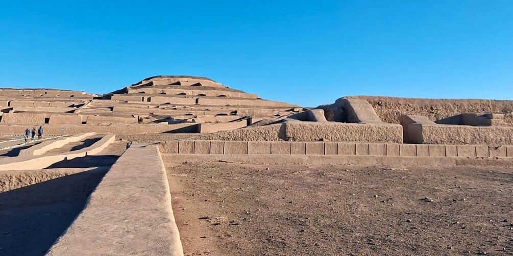 A large ancient step pyramid with multiple levels and a flat top, surrounded by a barren landscape. 4