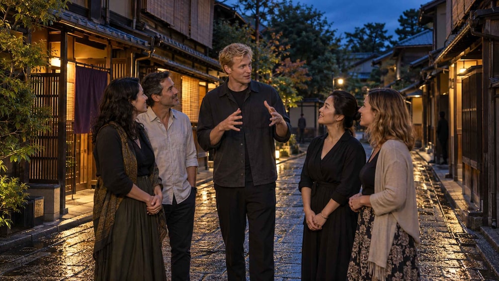 A group of people standing on a cobblestone street at dusk, with traditional wooden buildings on either side. 2