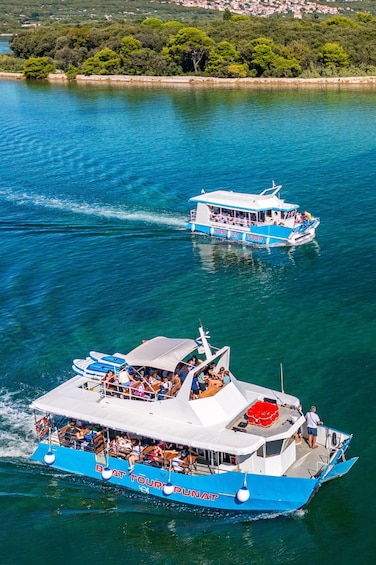 Two tour boats on a turquoise sea with a coastal town in the background. 4