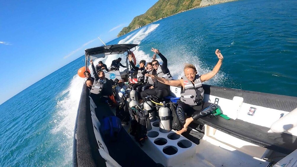 A group of people on a boat with a rocky coastline in the background. 4