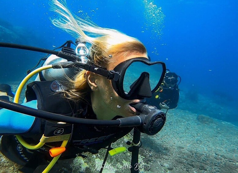 A diver with a scuba mask and snorkel underwater. 3