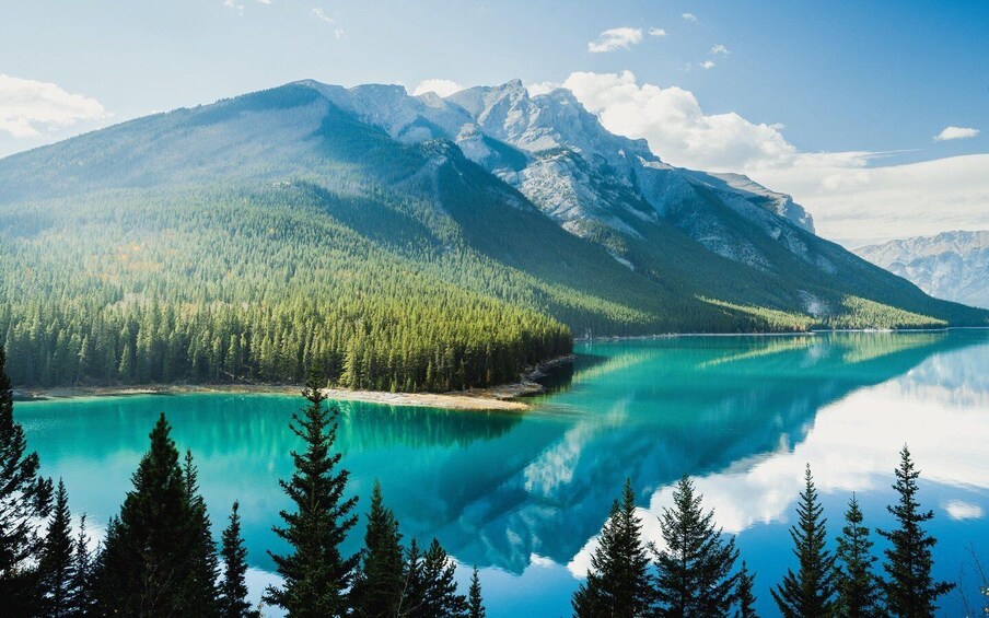 A mountain range, a turquoise lake, and dense forest. 4