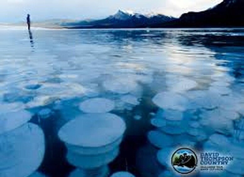 A frozen lake with ice floes and a person standing on the ice. 5