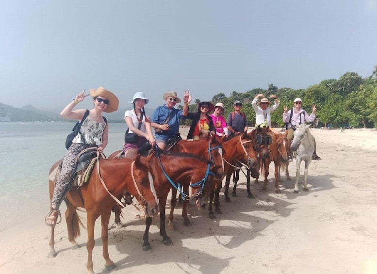 A group of people riding horses on a beach. 3