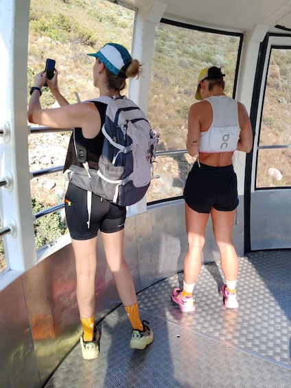 Two people standing on a metallic floor with a metal railing, one holding a smartphone. 4