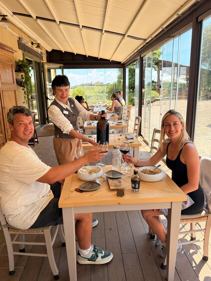 Un grupo de personas cenando al aire libre en un restaurante con vistas al campo. 2