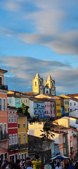 A colorful street with a church and people walking. 4