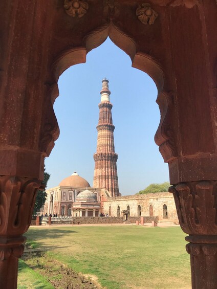 A historic tower with a spiral minaret, viewed through an ornate archway. 3