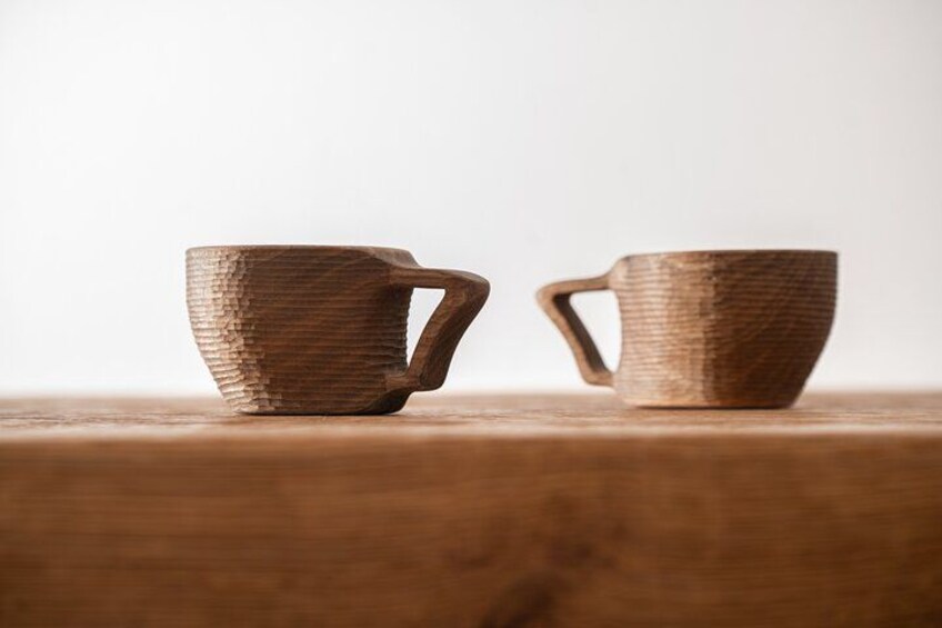 Two wooden cups with handles on a wooden surface. 5