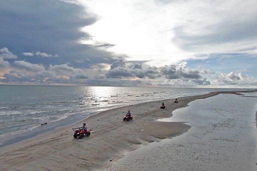 Una playa con arena, agua y nubes. 2