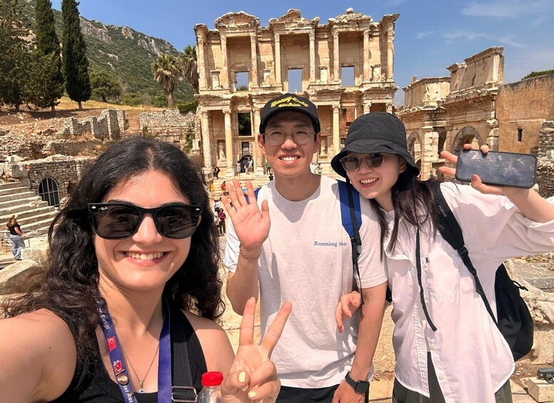 A group of people taking a selfie in front of ancient ruins with columns and steps. 4