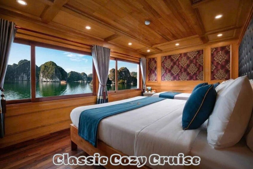 A cozy cruise cabin with wooden walls, large windows, and a bed with blue bedding. 1