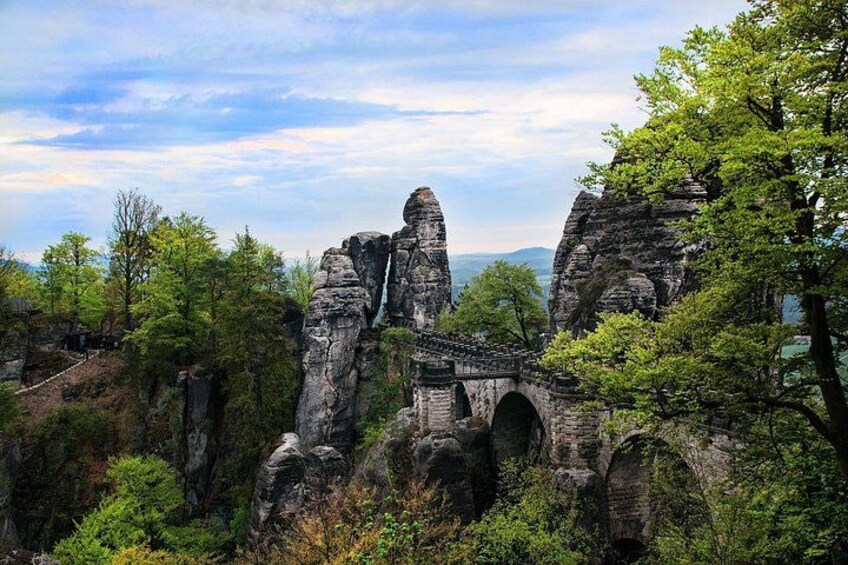 De vieilles ruines en pierre, avec un pont, entourées d’une végétation luxuriante et d’arbres. 2