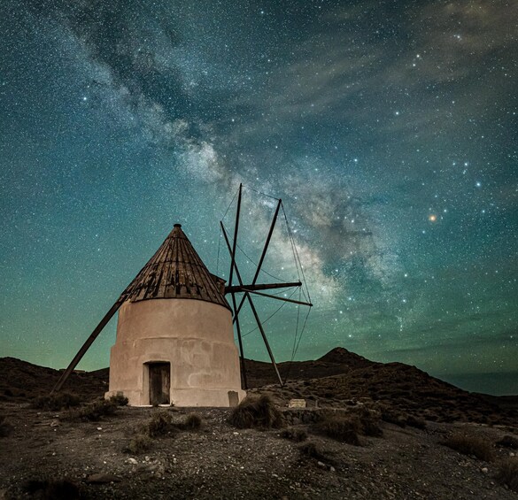 A traditional windmill under a starry night sky. 2