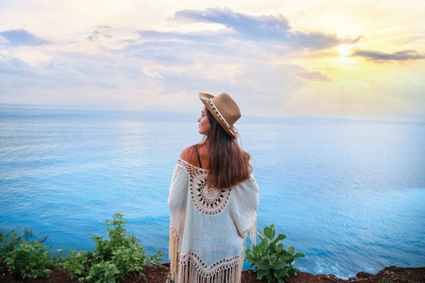 A person standing by the sea, wearing a hat and a white garment. 2