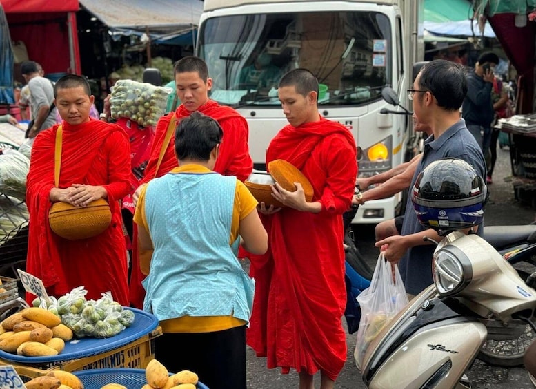 Monks in red robes at a market, interacting with vendors and customers. 4