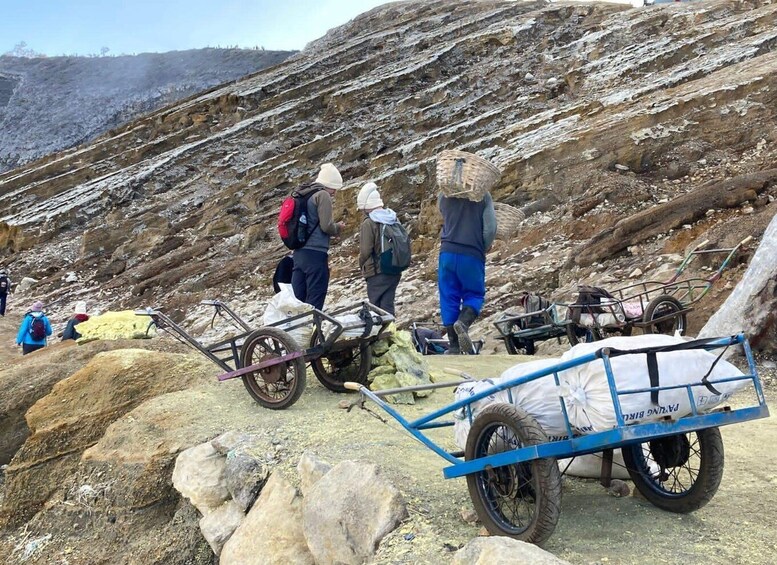 Hikers with carts on a rocky mountain path. 5