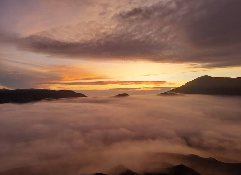 A sunrise over a mountain range with clouds below. 2