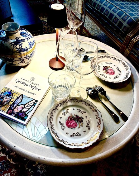 A table with a book, plates, glasses, and cutlery. 3