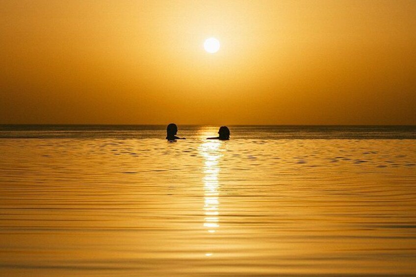 Two people watch the sunset in the pool 4