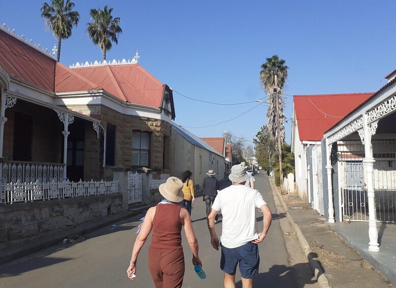 A street lined with colonial-style buildings, palm trees, and a clear blue sky. 3