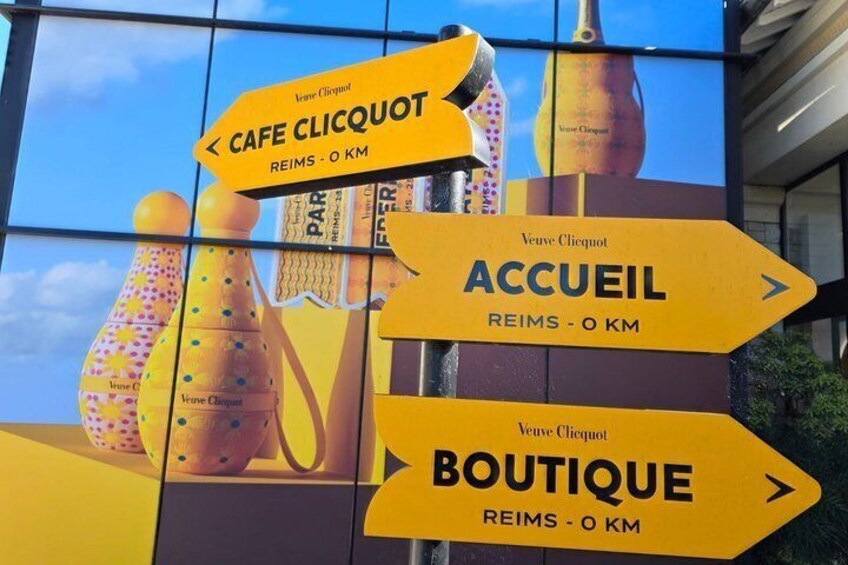 A sign with directions to Cafe Clicquot, Accueil, and Boutique, all 0 km away. 5