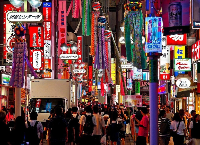 A crowded street with colorful neon signs and lanterns. 4