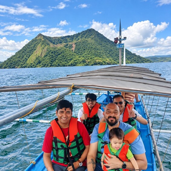 A group of people on a boat with a mountainous landscape in the background. 3