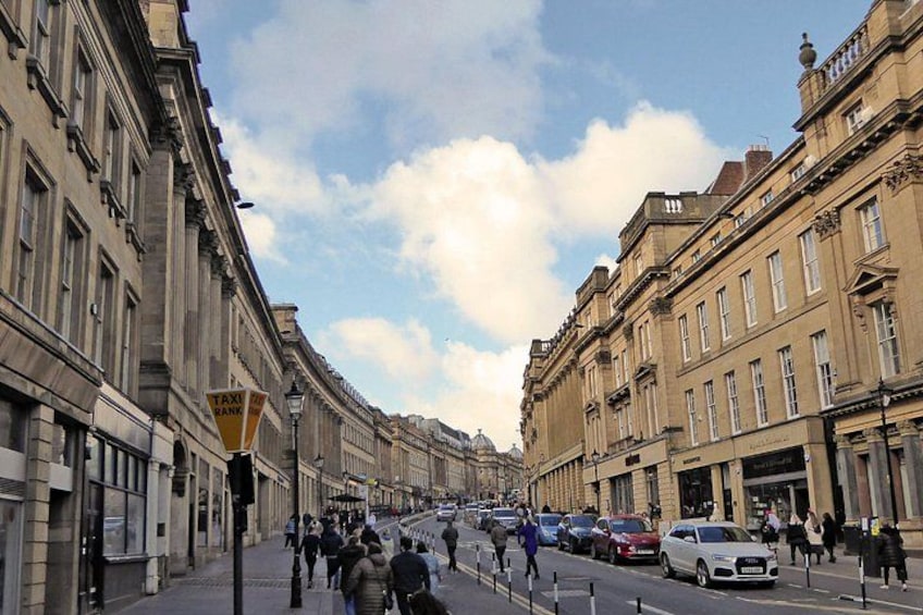 A street with buildings, a taxi sign, and cars. 3