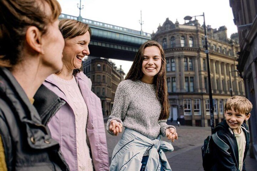 A group of people walking on a street with historic buildings in the background. 2