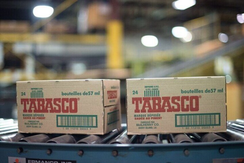 Deux boîtes de sauce Tabasco sur un tapis roulant dans un entrepôt. 5