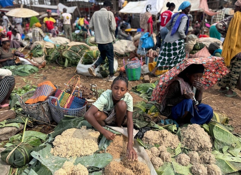 Un marché animé où les gens vendent et achètent toutes sortes de produits, notamment des sacs de céréales et des paniers aux couleurs vives. 1