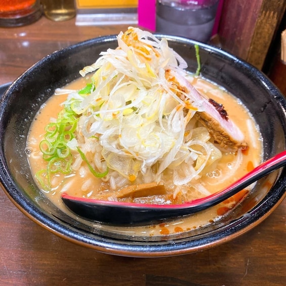 En skål med ramen, nudlar, skivat kött och salladslök. 4