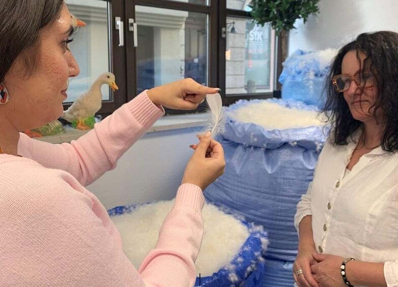 A person holding a feather near a large bag of white material. 3