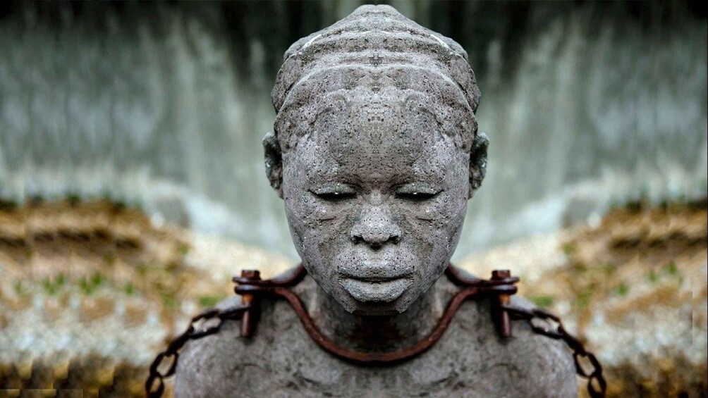 A stone statue with a chain around its neck. 1