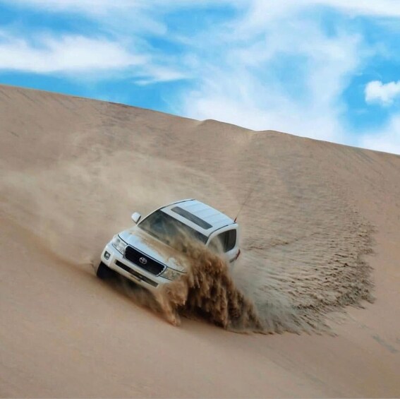 A white SUV driving through a sandy desert with a clear blue sky. 4