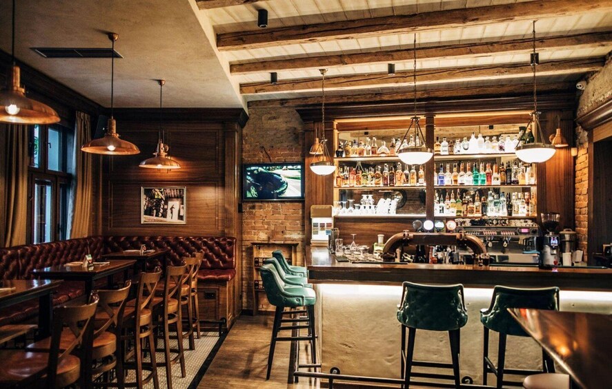 A bar with wooden beams, leather booths, and a well-stocked liquor shelf. 2